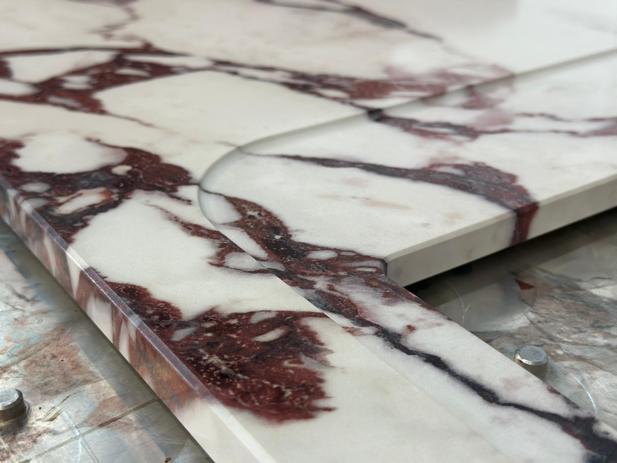 Close-up of a printed burgundy vein design across a curved fabricated edge.