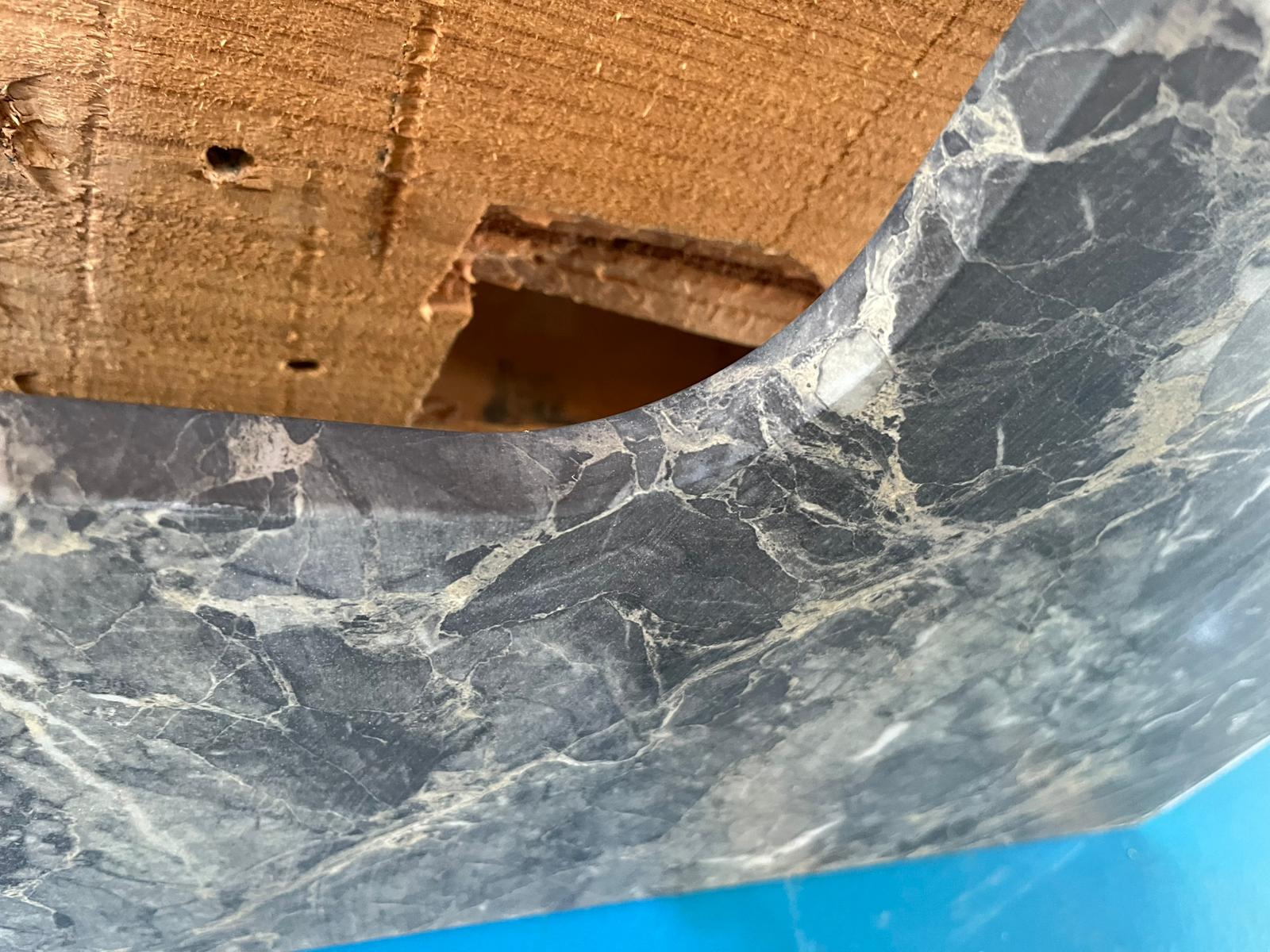 Close-up of a dark printed stone-effect surface and its curved edge.