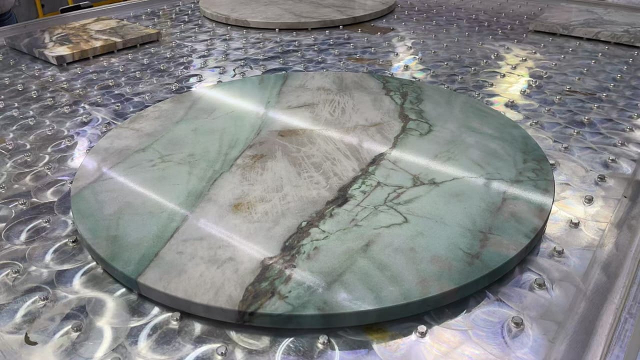 Circular surface with a green stone-effect design, photographed on the production table.
