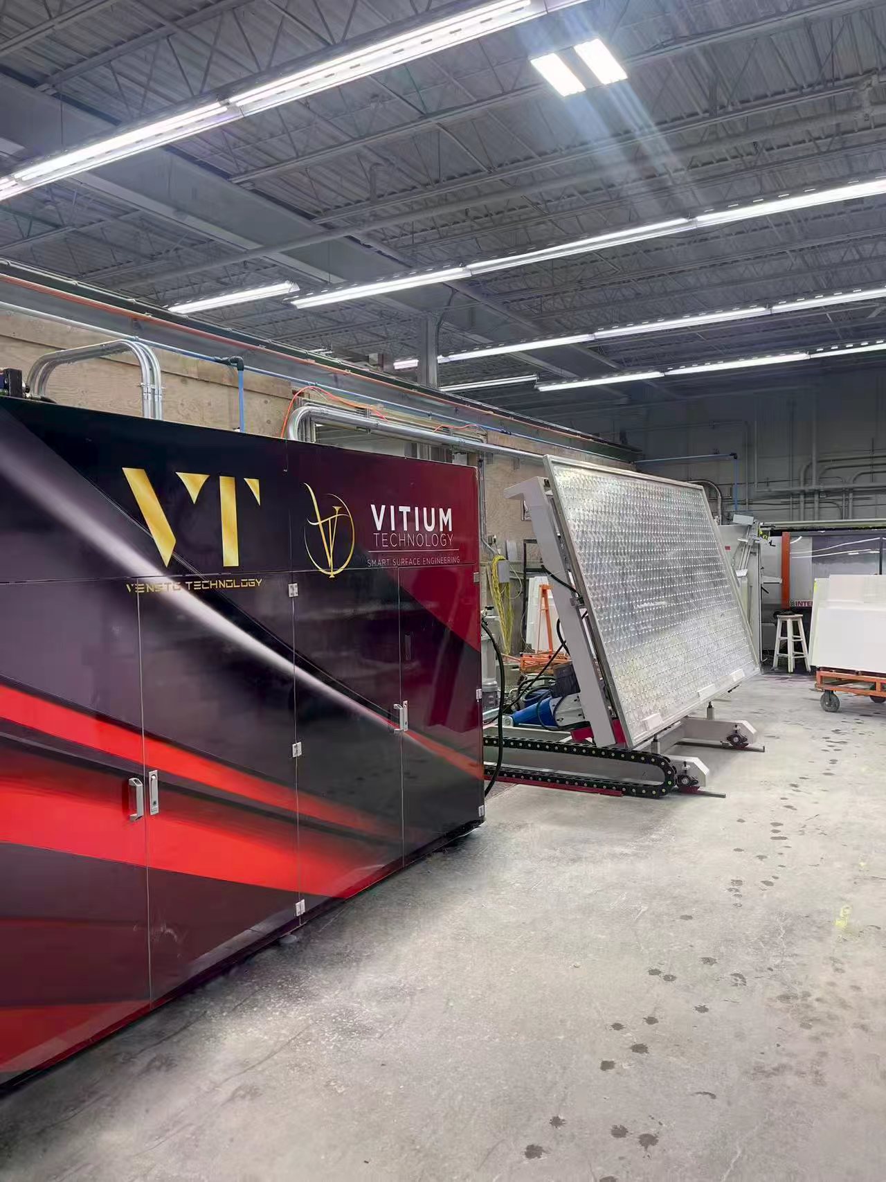 Vitium Hybrid photographed in the factory, with the machine enclosure and open processing table visible.