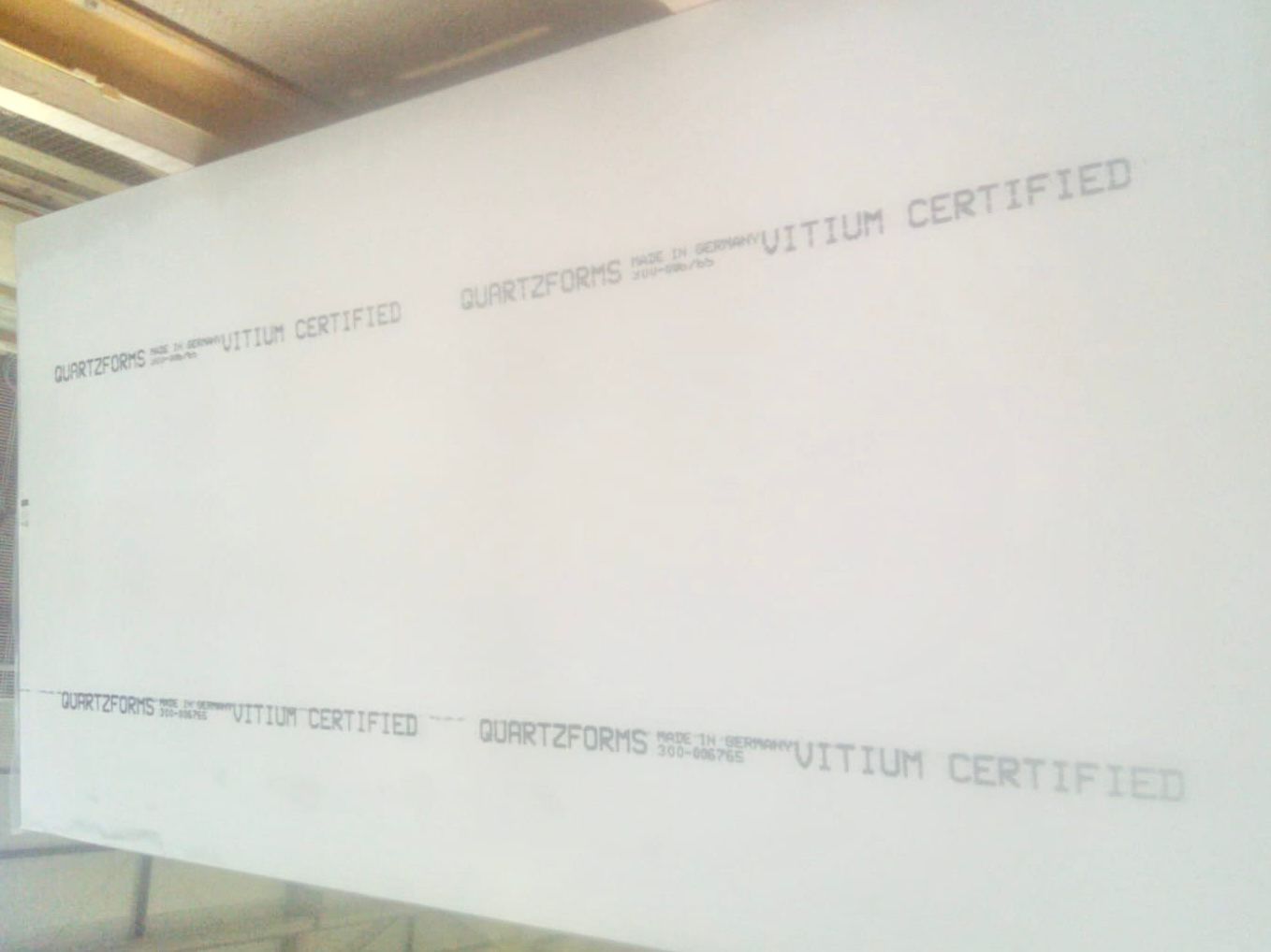 White mineral slab bearing Vitium Certified markings.